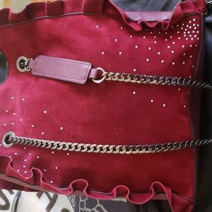 Maroon suede handbag.